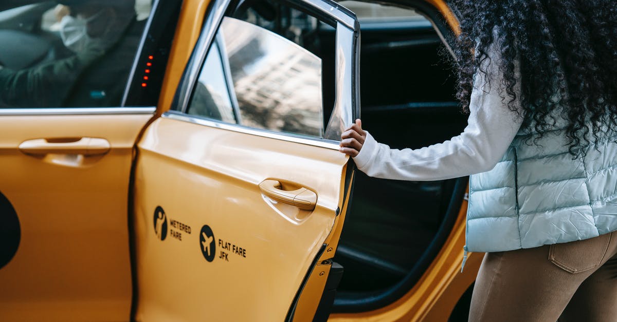 Long distance (16 hours) car trip with rental car and driver - Anonymous African American woman getting into cab parked on street