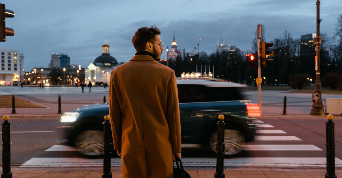 Long term Car rental in Europe - Man Wearing Brown Coat Standing on the Street