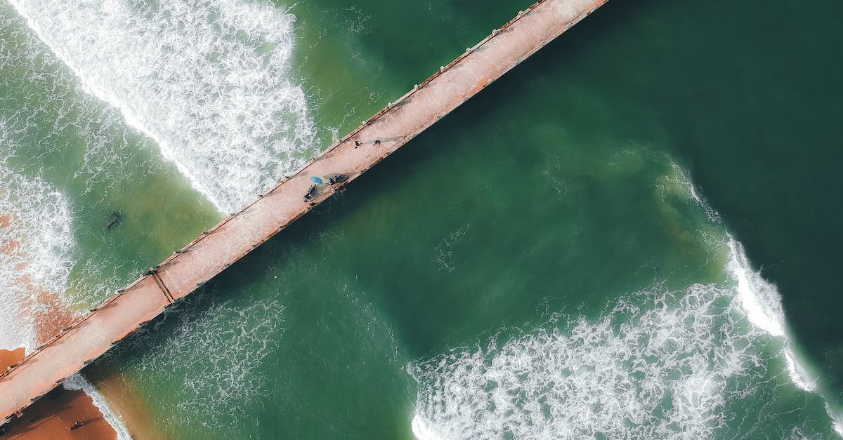 Long term vacation on Falkland islands? - Top view of wavy sea with sandy coast of beach and long concrete bridge