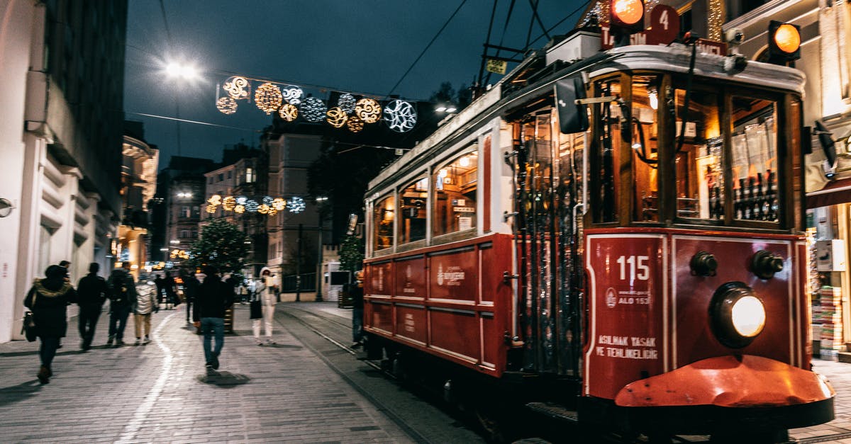 Long-distance Uber/Lyft ride around Christmas - Old tram riding on railway of city decorated with garlands