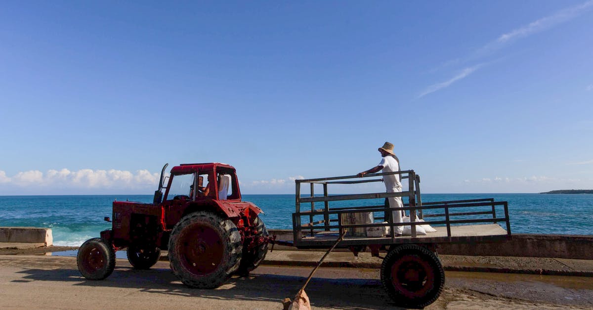 Long-ish term trailer rentals? - Man in White Shirt and Blue Denim Jeans Sitting on Red Tractor