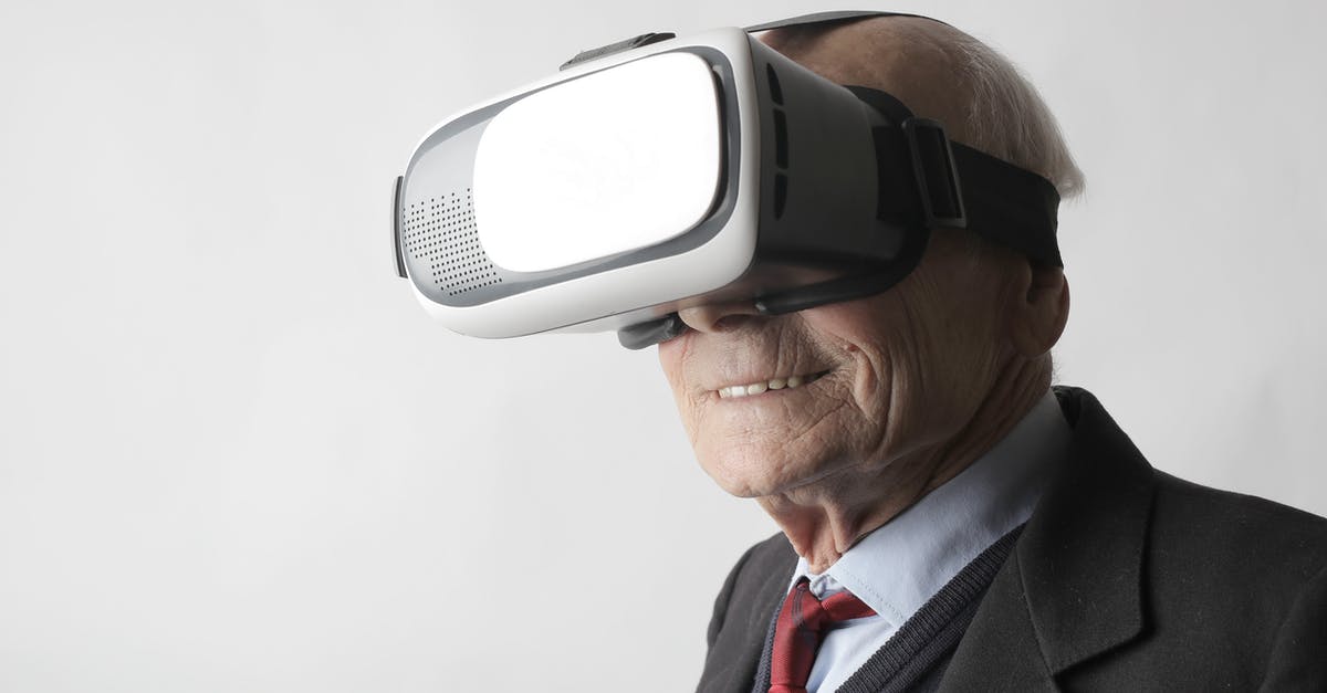 Looking for a contact address. Most disgusting experience with EasyJet - Smiling elderly gentleman wearing classy suit experiencing virtual reality while using modern headset on white background