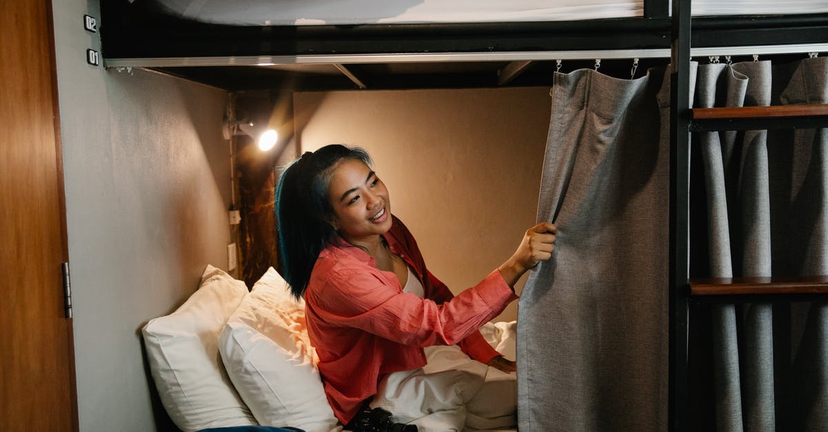 Lost camera on a Trenitalia train - Cheerful young ethnic woman sitting in bed