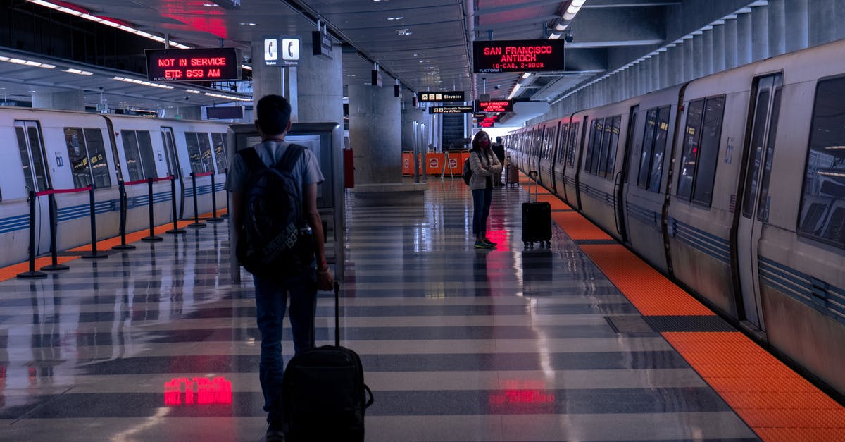 Luggage etiquette on European trains - A Man Holding his Luggage Walking on Train Station