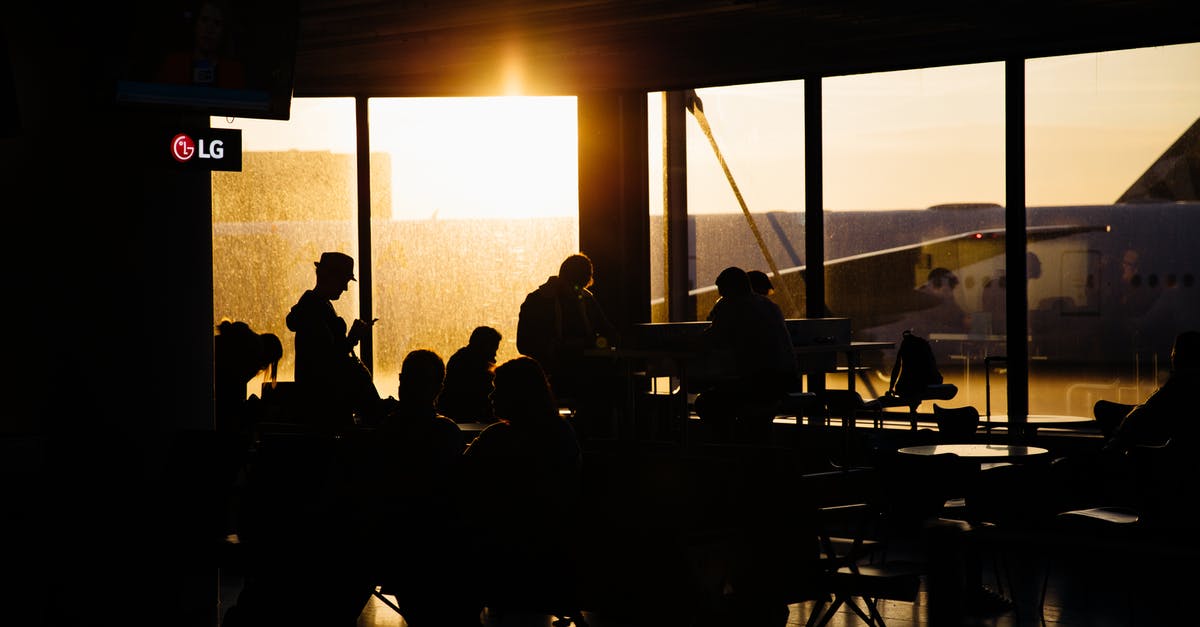 Luggage exchange between flights - Silhouette of People Sitting Inside the Airport