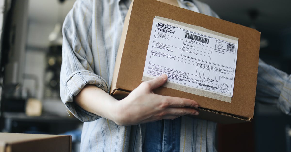 Mailing package at Heathrow during layover - Person Holding Brown Cardboard Box