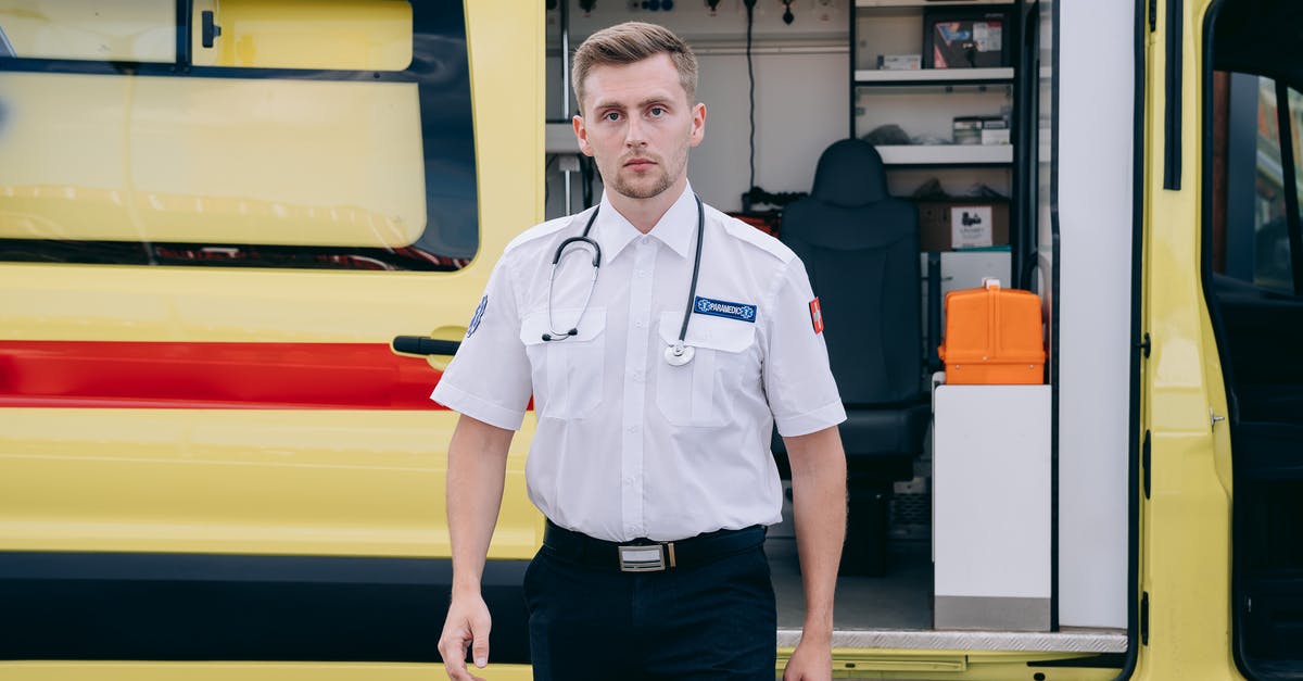 Making a rental car look inconspicuous - Paramedic Standing Beside an Ambulance