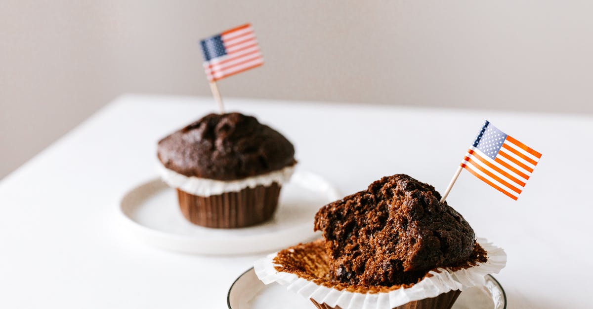 Making a short film while on holiday in the US - From above of bitten and whole festive chocolate cupcakes decorated with miniature american flags and placed on white table