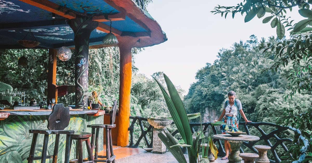 Malaria pills needed for jungle trip in Chiang Mai? - Female tourist standing near wooden fence of bar located among green lush exotic plants during vacation