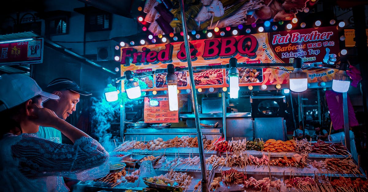 Malaysia Custom Regulation - Customer choosing raw kebab in street stall at night