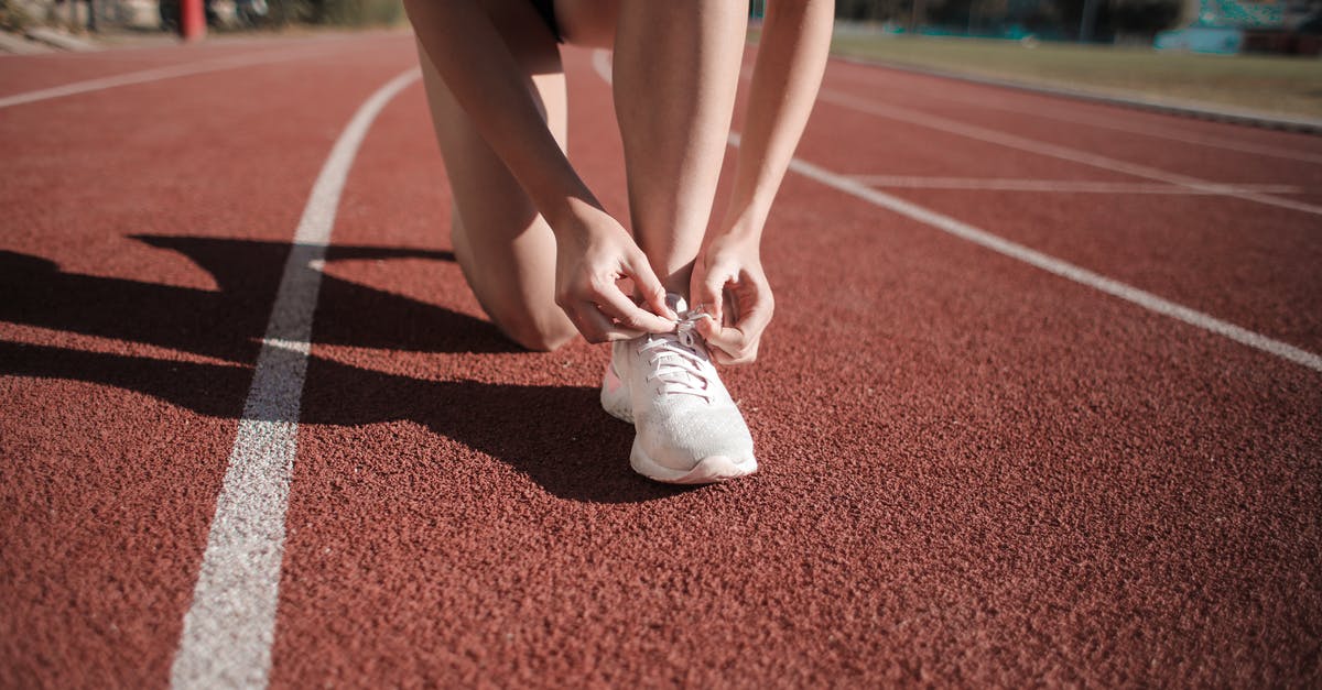 Malaysia Visa Run [closed] - Close-up Photo of Woman Tying Her white Sneakers on Running Track