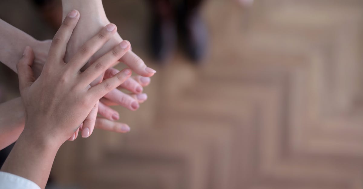 Male visiting Iran with younger female companion - Crop group stacking hands together