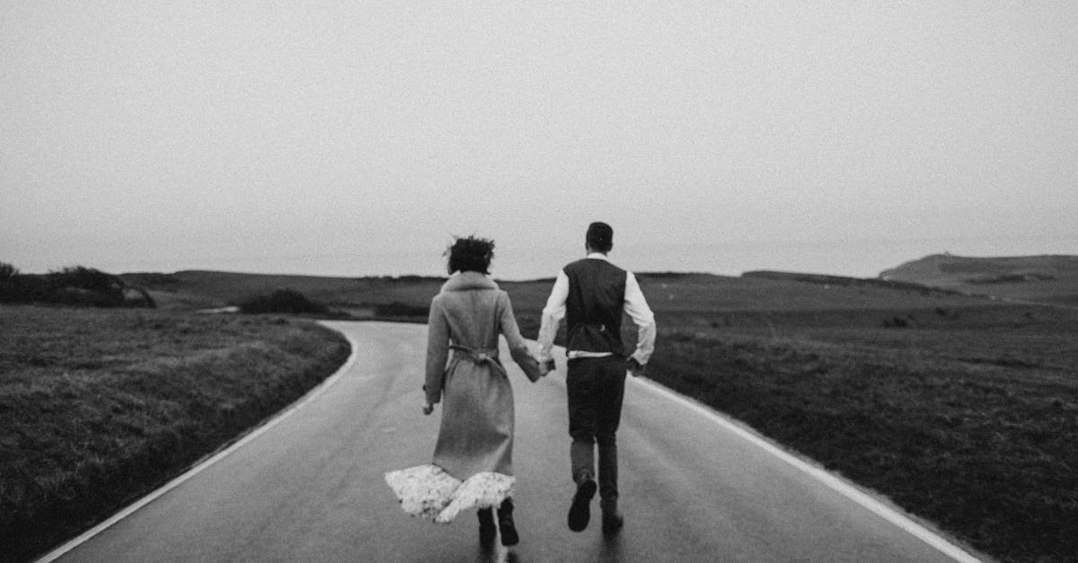 Marriage in the UK and go back to our country - Grayscale Photo of Couple Walking on Road