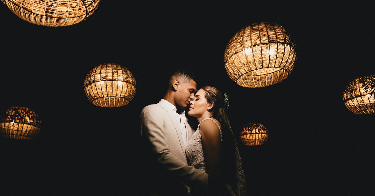 Marrying my Brazilian Fiance / Fiance visa [closed] - Romantic ethnic newlywed couple wearing classy wedding outfits embracing gently with eyes closed in dark studio decorated with shiny creative lanterns