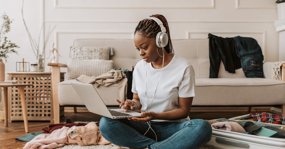 Maximum luggage dimensions when traveling Platzkart? - A Woman Using Her Laptop with Headphones On