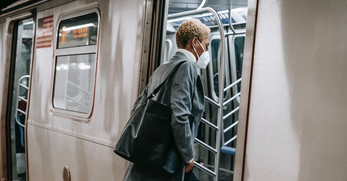 May an Estonian enter Germany at FRA during COVID-19? - Black woman in mask entering metro train