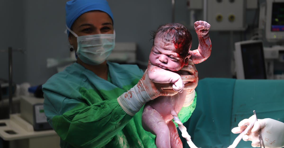 Medical coverage travelling to place of birth - Doctor Holding Newborn