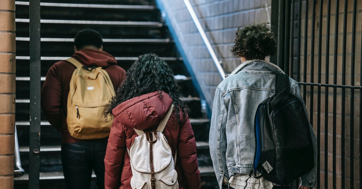 Meeting someone at the airport gate in the US? - Group of young students walking near stairs