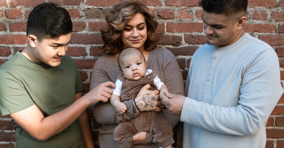 Mexican visa for Taiwanese person while travelling - A Woman Carrying Her Baby Boy while Standing Between the Father and His Son