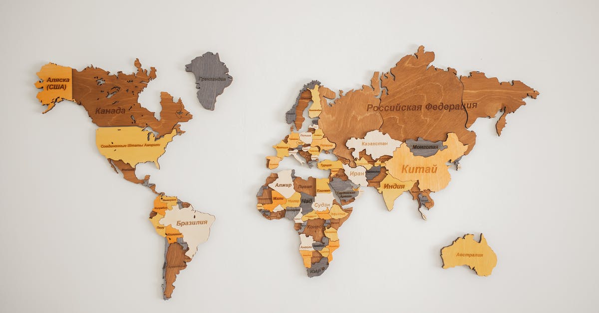 Missed country on Global Entry application - Decorative creative wooden world continents with country names written in Cyrillic attached on white background in light room of studio