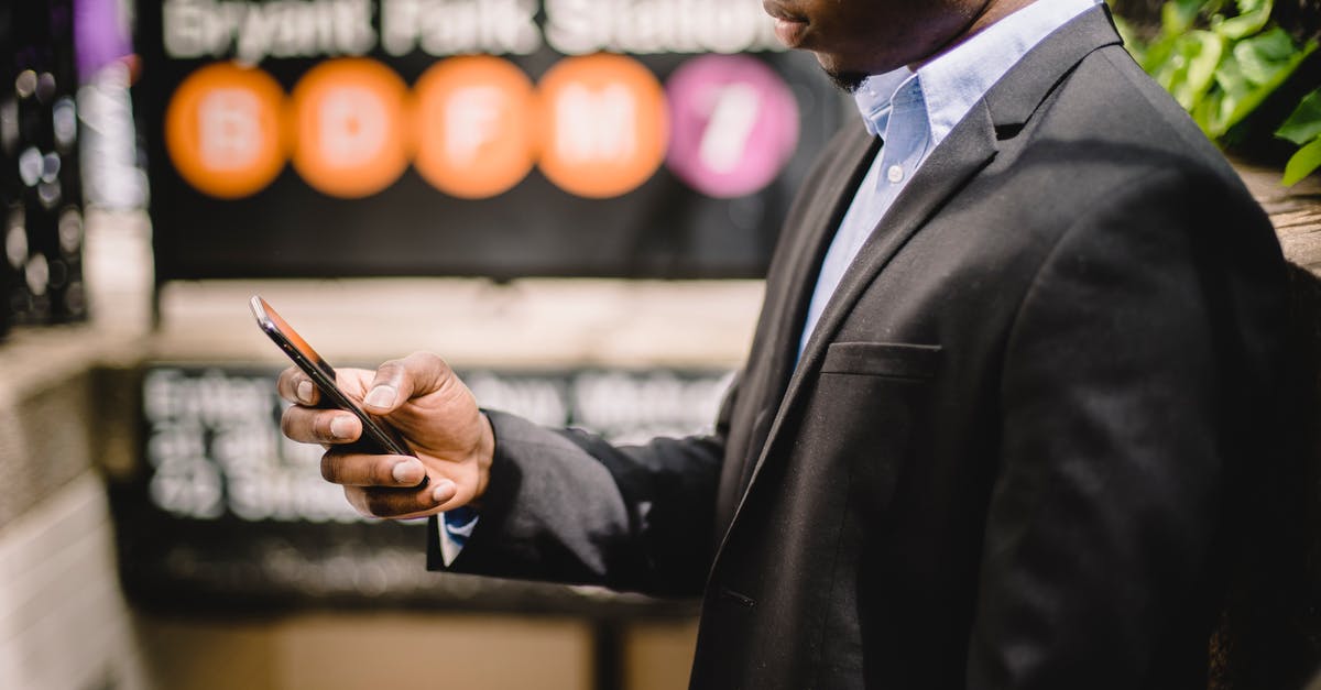 Mobile internet in New York City - African American office employee using cellhone on street