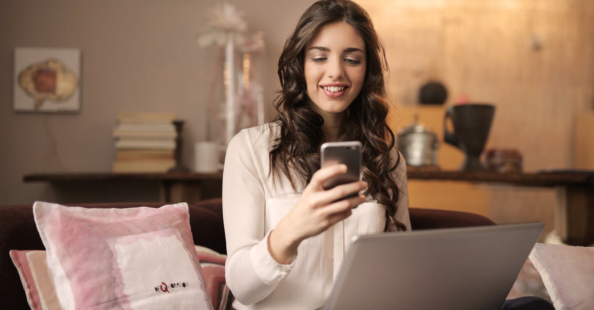 Mobile internet in the Caucasus - Woman Sitting on Sofa While Looking at Phone With Laptop on Lap