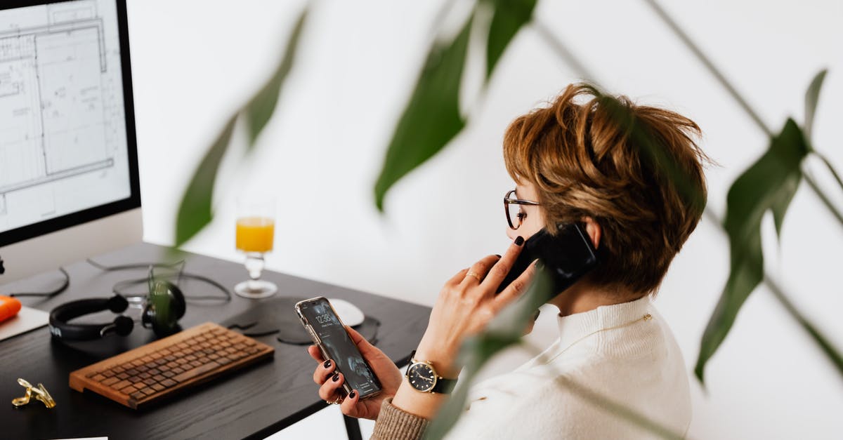 Mobile phone connection in Macedonia for short visit - Busy female talking on smartphone and checking messages during work in contemporary office