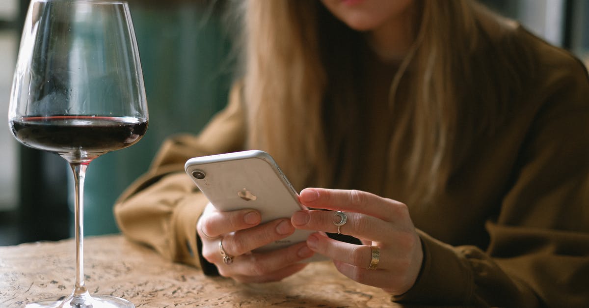 Mobile Wifi Rental in Turkey? - Woman Sitting with a Glass of Wine Scrolling Through Her Phone 