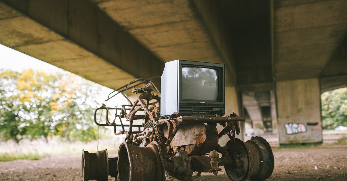 Monitor in Checked Luggage - Damage by Vibration/Shaking? [duplicate] - Old damaged vehicle with vintage television set on rough pathway under bridge in sunlight