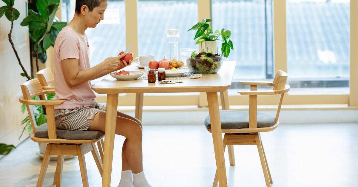 Morning-after pill availability in Poland - Woman cutting fruits at table in modern kitchen in daylight