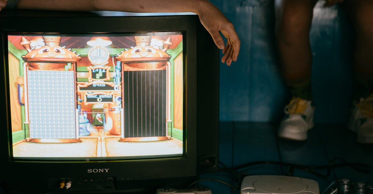 Most respectful way to set alarm when sharing the room - Crop unrecognizable female on modern monitor with video game on screen near ethnic partner