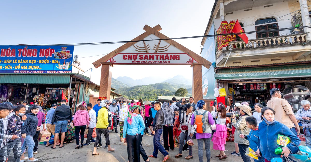 Mount Everest without the crowd - Anonymous ethnic people strolling on walkway against buildings and misty mountains in local bazaar in town