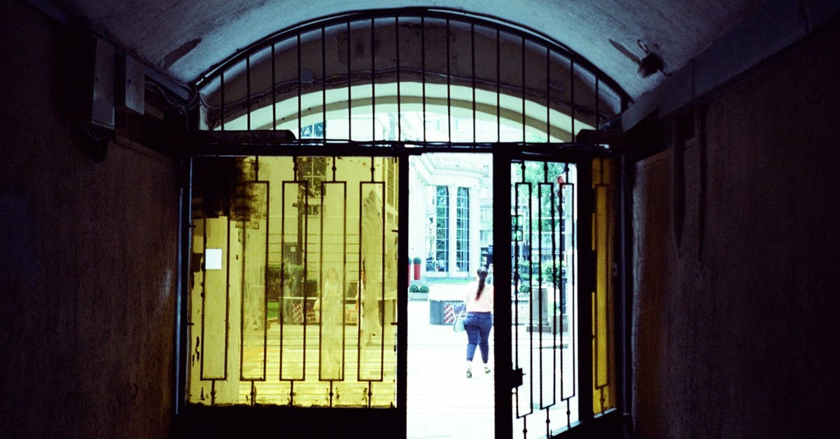 Multiple Entry schengen visa second trip - Half opened gate with glass windows of old passage leading to city street in daylight