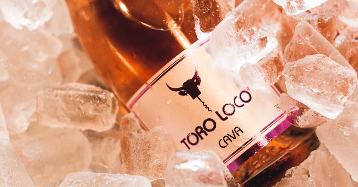 Must goods be unused to get Spanish VAT refunded? - From above of bottle of wine with logo of bull placed in cold ice cubes