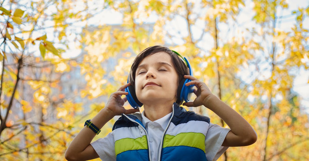 Must hearing aids be taken off when passing through security? - Photo of a Boy Listening in Headphones