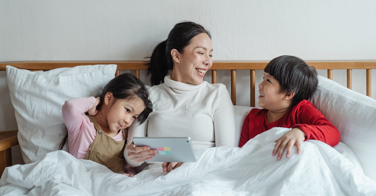 Must one always have one's passport when using NEXUS? - Positive ethnic mother and little daughter and son having fun together in cozy bed in morning while using tablet