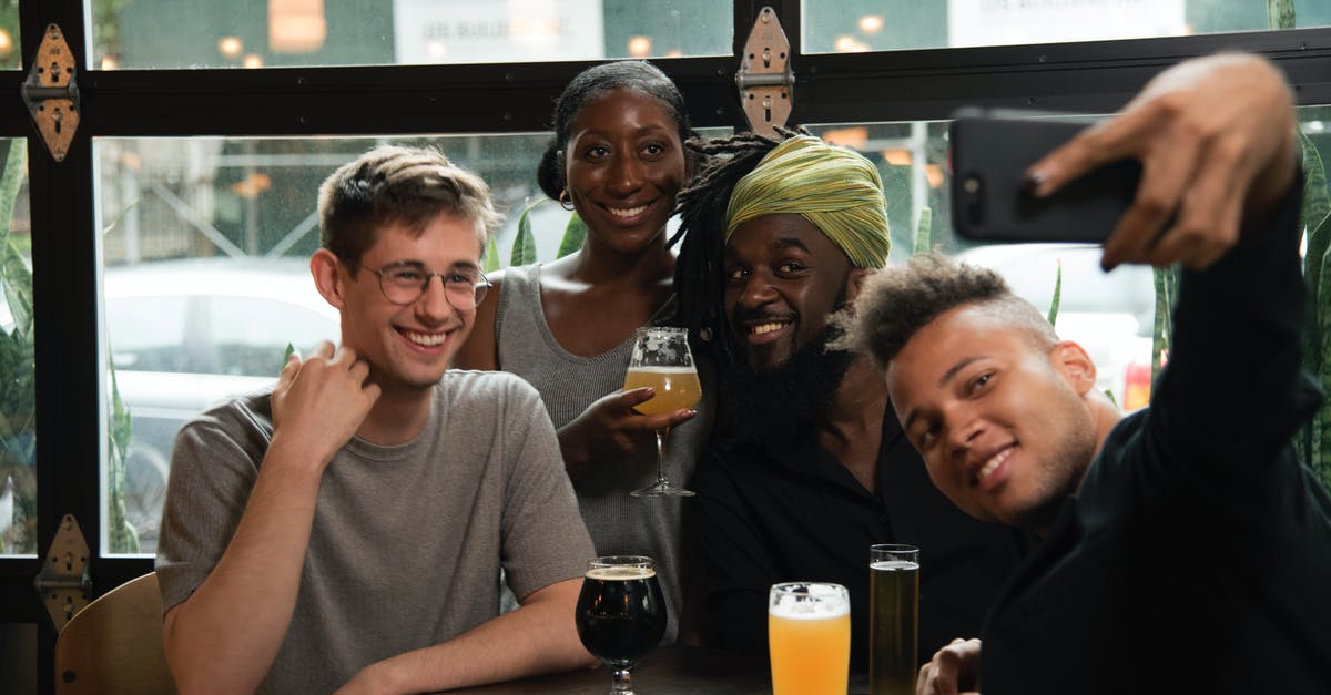 My friend used his friend's credit card for flight [closed] - Happy multiethnic friends taking selfie on smartphone in cafe