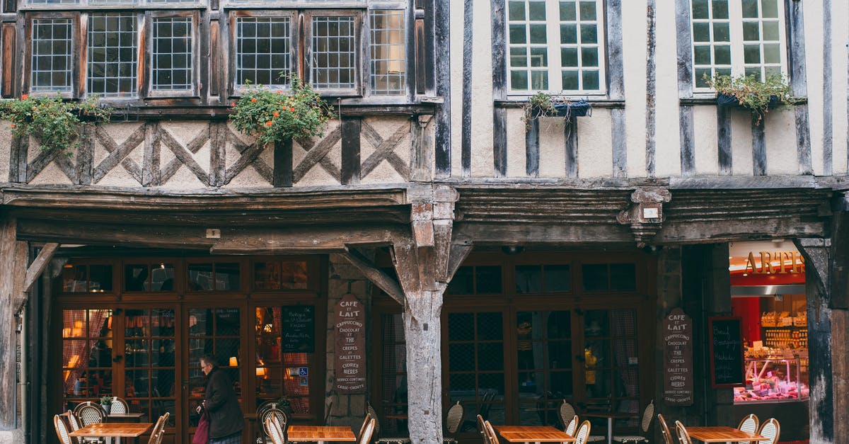 Name of restaurant in Kitzingen, Germany - Exterior with authentic stone building with outdoor cafe