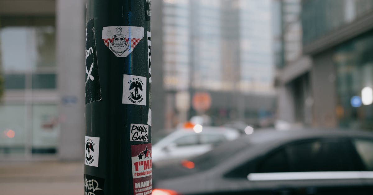 Name on driving license slightly different from Passport - Stickers attached to pillar on city street