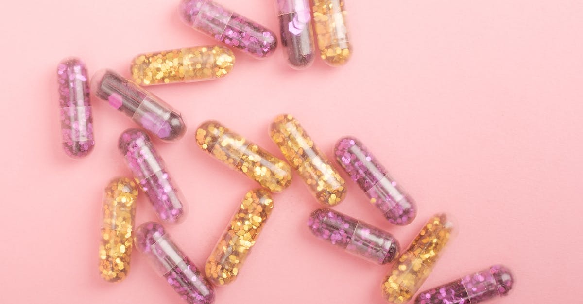 Need malaria medication for Rajasthan in July / August? - Pile of sparkling drug capsules scattered on pink surface