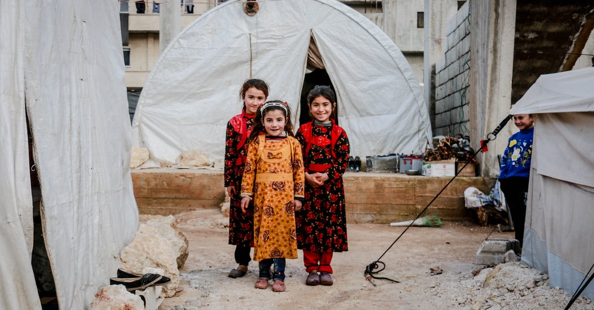 Need to add children to wife's itinerary - Three Girls in Floral Dresses Smiling and Standing Near White Tent