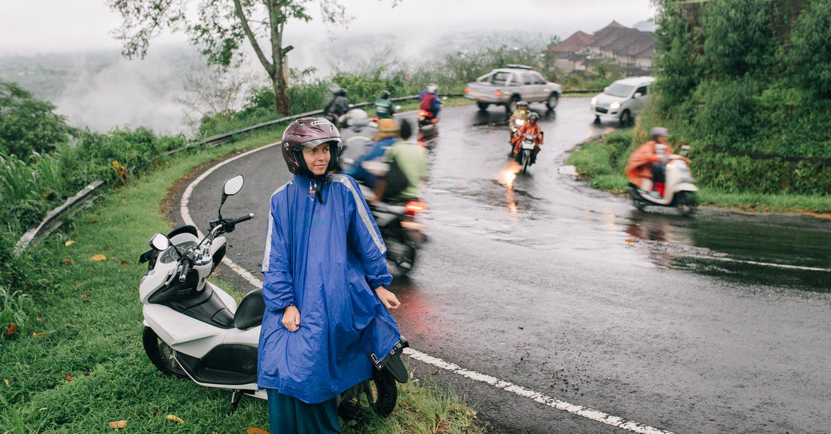 Nepal: How bad is the rainy season? - A Woman in  Raincoat Sitting on a Motorcycle Beside the Road