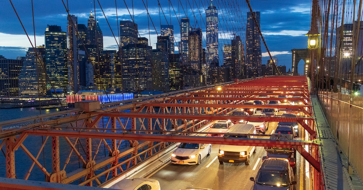 New York airports: JFK vs. EWR/Newark? - Red Metal Bridge over River during Night Time