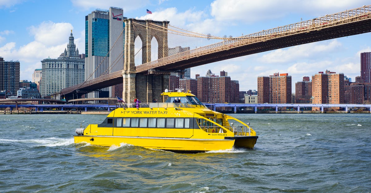 New York subway Q train - view of Brooklyn Bridge - Yellow vessel boat sailing on river near bridge