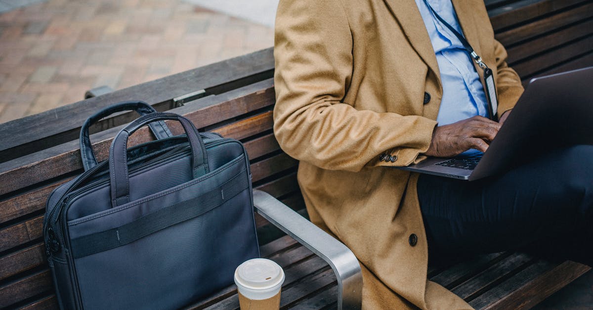 NOC from employer for Schengen visa - Crop faceless black man using laptop on street bench