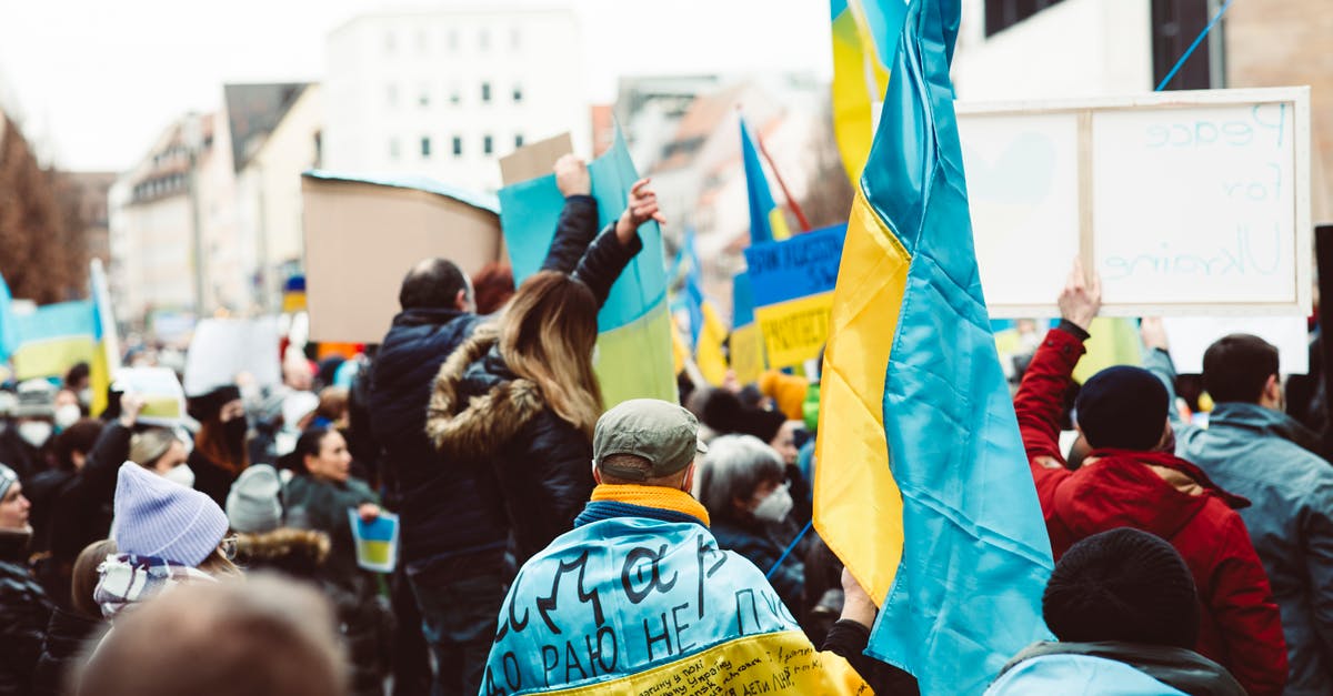 Non EU travelling with minor EU children to UK - People in Blue and Yellow Jacket Raising Hands