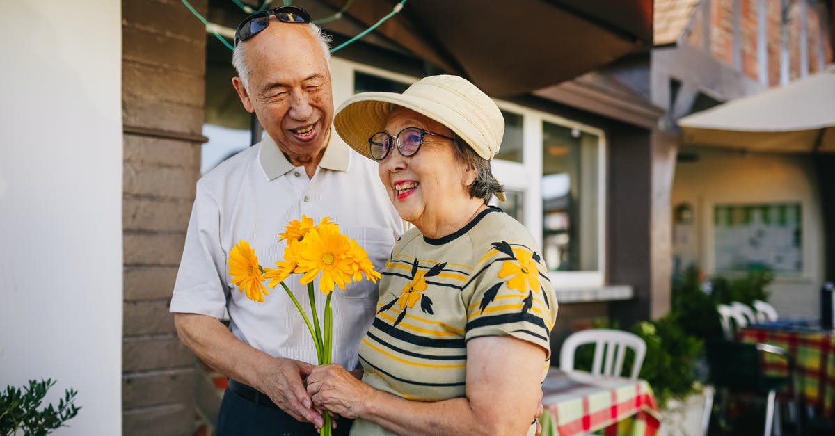 Non-EEA Family Member of EEA Citizen Traveling to UK - Elderly Couple Holding Bouquet of Flowers while Holding Hands