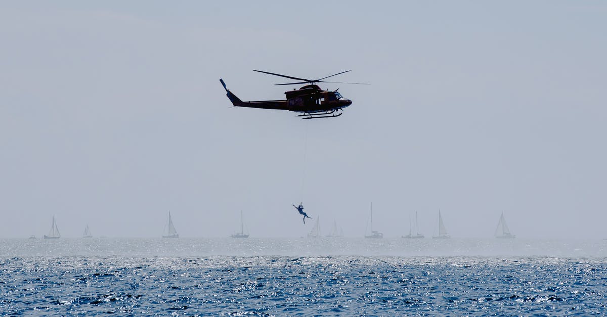 Normandy, France: Where to see the WW2 landing craft? - Copter landing anonymous military parachutist over wavy ocean with sailboats during professional practice in daytime