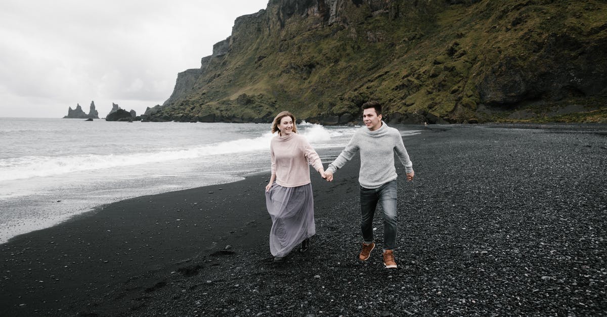 North Sea to Black Sea by own yacht [closed] - Happy loving couple holding hands and exploring magnificent black gravel beach while enjoying weekend at cliffy seacoast