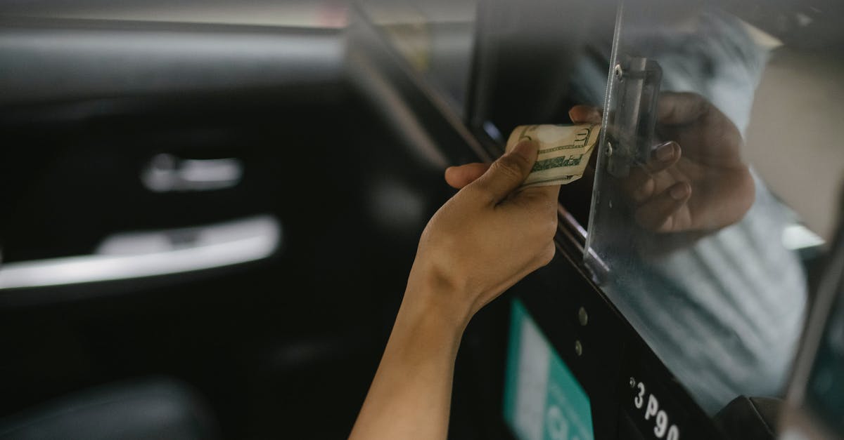 Not all tolls can be paid with cash. What are my options with a rental car? - Interior of modern taxi car while passenger paying for ride Not all tolls can be paid with cash. What are my options with a rental car? - Interior of modern taxi car while passenger paying for ride